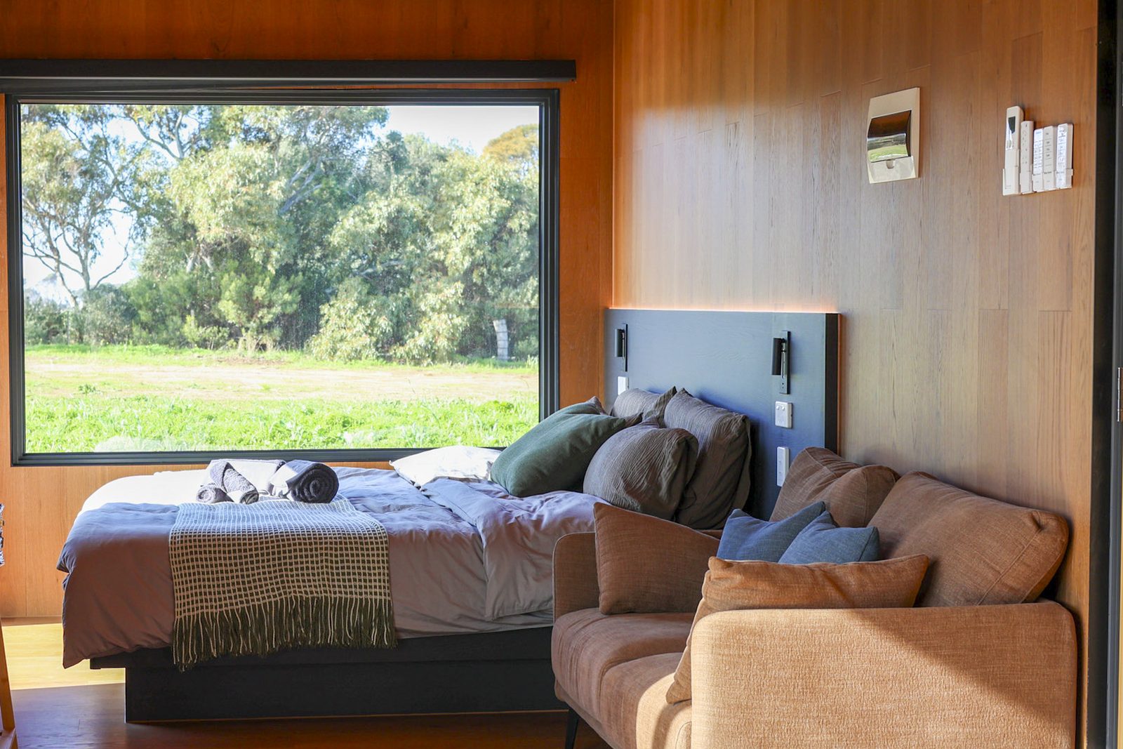 A step-free accessible retreat: wide circulation, bed and sofa under a large window